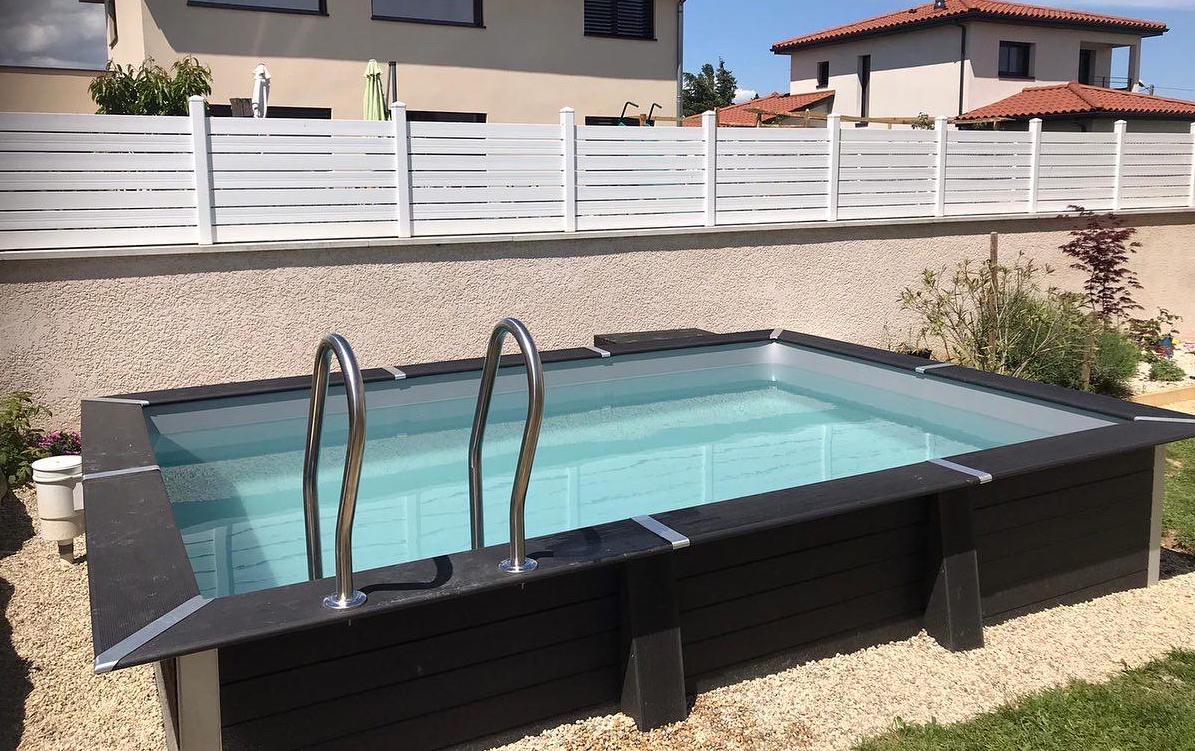 Petite piscine rectangulaire noire vue de côté en face d'un mur