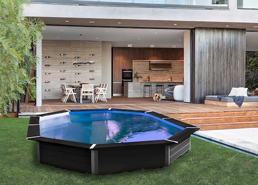 Photograph of a black semi-sunken pool in the garden of a villa