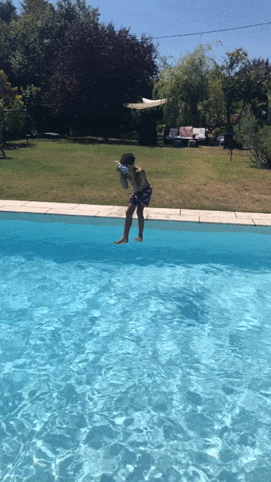 Animated image of a child jumping into a pool located in a garden